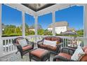 Relaxing screened porch with wicker furniture and tranquil backyard view at 117 Hardy Oaks Way, Holly Springs, NC 27540
