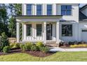 Farmhouse style home with a front porch and landscaping at 6045 Scalybark Road, Durham, NC 27712