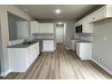 Modern kitchen with white cabinets, granite countertops, and LVP flooring at 726 Sherrill Farm Dr, Benson, NC 27504