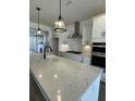 Modern kitchen with white cabinets, quartz countertops, and stainless steel appliances at 124 Swain St, Clayton, NC 27527