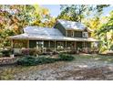 Front view of a two-story green house with a wrap-around porch at 7925 S Highway 55, Willow Springs, NC 27592