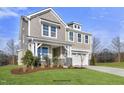 Two-story home with gray siding, stone accents, and a landscaped lawn at 71 Macy Cir, Wendell, NC 27591