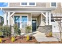 Inviting front porch with stone columns and a dark-colored front door at 71 Macy Cir, Wendell, NC 27591