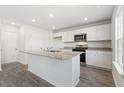 Modern kitchen with white cabinets, granite countertops, and stainless steel appliances at 210 Bay Laurel Dr, Sanford, NC 27332