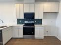 Modern kitchen with white cabinets, hexagon tile backsplash, and stainless steel appliances at 1639 Wendell Valley Blvd, Wendell, NC 27591