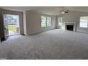 Open living room with grey carpet, fireplace, and high ceiling at 378 Magnolia Run Way, Benson, NC 27504