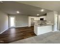 Open kitchen with white cabinets, granite countertops, and a breakfast bar at 79 Tulipfield Way, Benson, NC 27504