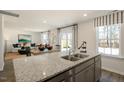 Open concept kitchen with granite island and view to living room at 233 Holton St, Smithfield, NC 27577