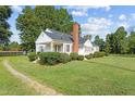 White house with brick chimney, side view showcasing landscaping at 9847 Snow Camp Rd, Snow Camp, NC 27349