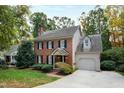 Brick home with a gray garage, shutters, and landscaping at 2257 Brisbayne Cir, Raleigh, NC 27615