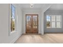 Bright and spacious entryway with hardwood floors, large windows, and a stunning wooden door at 2105 Gentry Rd, Wake Forest, NC 27587