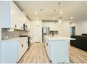 Modern kitchen with white cabinets, large island, and stainless steel appliances at 2034 Florine Drive Dr, Apex, NC 27502