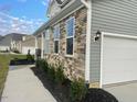 Side view of a two-story house showcasing stonework and garage at 87 Browning Mill Dr, Wendell, NC 27591