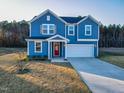 Two-story blue house with red door and attached garage at 316 Robert Howe Dr, Fuquay Varina, NC 27526