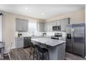 Spacious kitchen with gray cabinets, granite island, and stainless steel appliances at 660 Dallas Rose Dr, Wendell, NC 27591