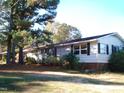 White ranch house with black shutters and side yard landscaping at 6383 Elevation Rd, Benson, NC 27504