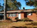 Brick ranch house with covered porch, mature landscaping, and a spacious yard at 6383 Elevation Rd, Benson, NC 27504