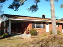Brick ranch house with covered porch, mature landscaping, and a spacious yard at 6383 Elevation Rd, Benson, NC 27504