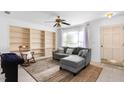 L-shaped living room with built-in shelving, rocking chair and ceiling fan at 1812 Orange Grove Rd # 101, Hillsborough, NC 27278