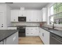 Modern kitchen with white cabinets, dark countertops, and stainless steel appliances at 901 Myers Point Dr # 17, Morrisville, NC 27560