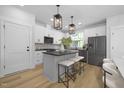Modern kitchen with gray island, white cabinets, and black appliances at 901 Myers Point Dr # 17, Morrisville, NC 27560