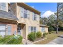 Tan two-story townhome with gray shutters and landscaping at 14 Stone Village Ct, Durham, NC 27704