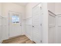 Bright foyer with white wainscoting, wood-look floors, and a coat closet at 33 Barony Ln, Smithfield, NC 27577