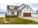 White farmhouse exterior with brown garage door and landscaping at 181 Glenwood Pl, Kenly, NC 27542