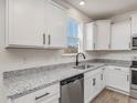 White cabinets, granite countertops, and stainless steel appliances are featured in this kitchen at 579 Winding Creek Dr, Lillington, NC 27546
