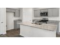 Modern kitchen island with gray cabinets and granite countertops at 236 Holton St, Smithfield, NC 27577