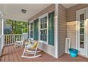 Front porch with rocking chairs and a welcoming sign at 1209 Trotter Bluffs Dr, Holly Springs, NC 27540