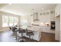 Modern kitchen with white cabinets, large island, and stainless steel appliances at 2892 Huxley Way, Apex, NC 27502