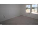 Empty bedroom with new carpeting and two windows at 7118 Hubner Pl # 39, Cary, NC 27519