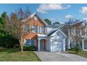 Two-story brick and vinyl home with a two-car garage and landscaped lawn at 142 Brentfield Loop, Morrisville, NC 27560