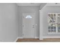 Front entry with white door, wood flooring and adjacent window at 142 Brentfield Loop, Morrisville, NC 27560