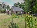 Side view of the house showcasing the backyard and landscaping at 178 Paceville Rd, Selma, NC 27576