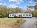 White manufactured home with a long driveway and wooded backdrop at 60 Bogey Ln, Louisburg, NC 27549