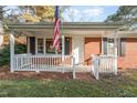 Brick ranch house with a covered porch and white railing at 6650 Cokesbury Rd, Fuquay Varina, NC 27526