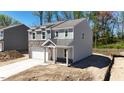 Two-story house with gray siding, stone accents, and a two-car garage at 281 Logan Creek Dr, Zebulon, NC 27597