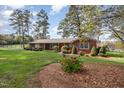Brick ranch house with a well-manicured lawn and mature trees at 739 Silk Hope Lindley Mill Rd, Siler City, NC 27344