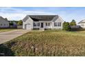 White house with a dark door, attached garage, and a small front porch at 96 Abram Ct, Broadway, NC 27505
