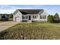 Simple white house with a dark door, attached garage, and a small front porch at 96 Abram Ct, Broadway, NC 27505