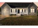 Gray and white house with a dark door, attached garage, and a small front porch at 96 Abram Ct, Broadway, NC 27505