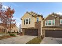 Front view of tan and brown brick townhome at 1203 Lotus Lilly Dr, Durham, NC 27713