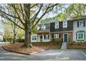 Two-story brick townhouse with a tree-lined street and parking at 1321 Dylan Heath Ct, Raleigh, NC 27608