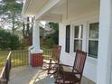 Front porch with two rocking chairs and metal railing at 509 E Church St, Nashville, NC 27856