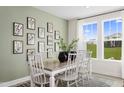 Bright dining room features a farmhouse table, botanical wall art, and a view of the backyard at 45 Lavender Ln # 173, Clayton, NC 27520