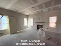 Unfinished living room with fireplace, several windows, and white walls at 78 Bennett Rd, Coats, NC 27521