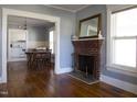 Living room with hardwood floors, fireplace, and view of kitchen at 823 E Holly St, Rocky Mount, NC 27801