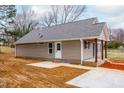 Tan vinyl sided home with rear patio and landscaping at 1329 Cloverdale St, Burlington, NC 27215